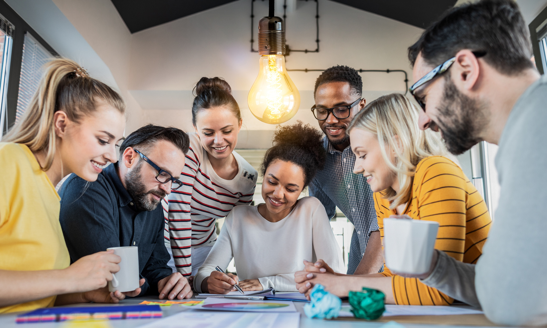 A diverse group of people working together at a table.